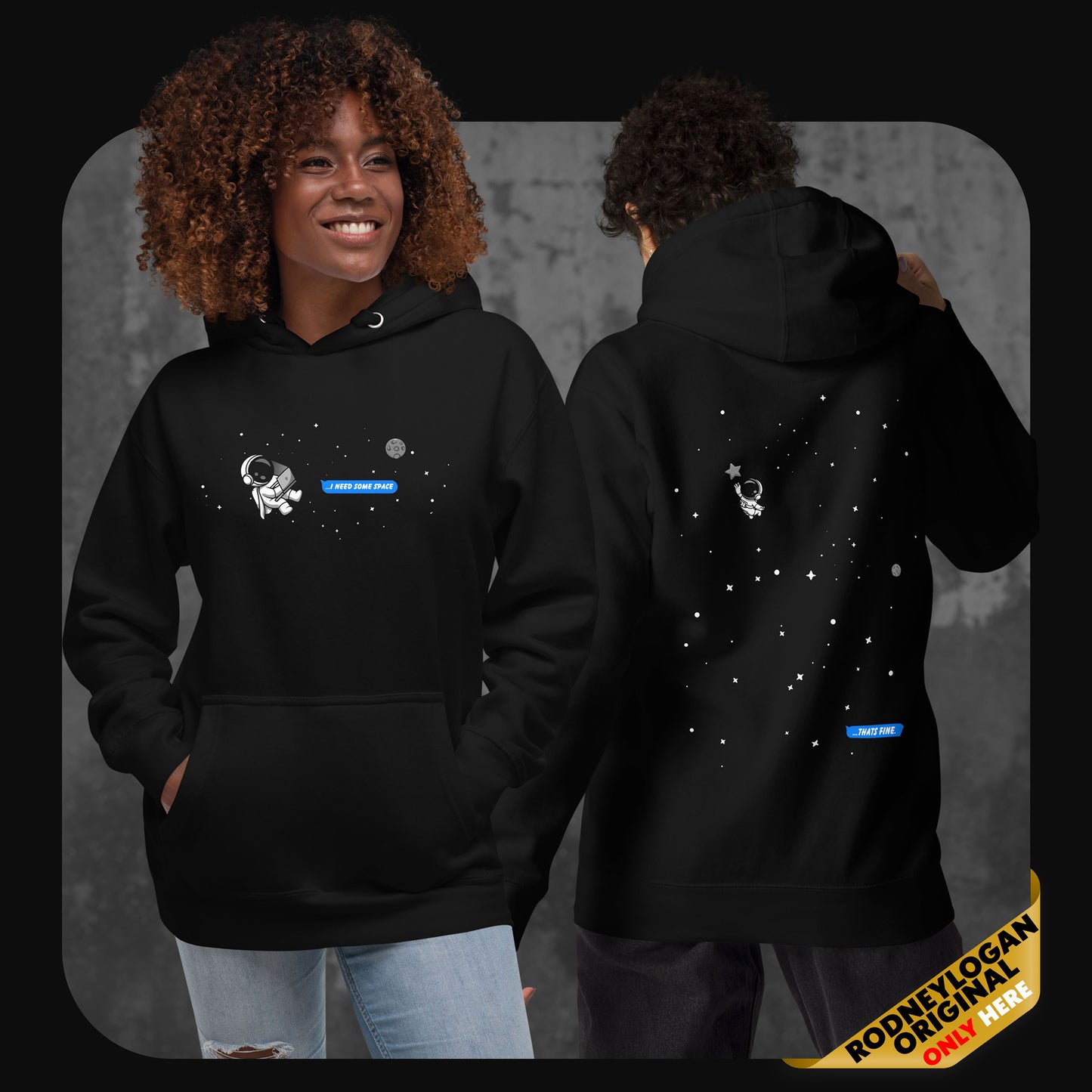 Lifestyle image showing two models wearing the black “I Need Some Space” hoodie – one facing forward with the astronaut and message on the chest, the other turned around revealing the back design with stars and the distant astronaut.