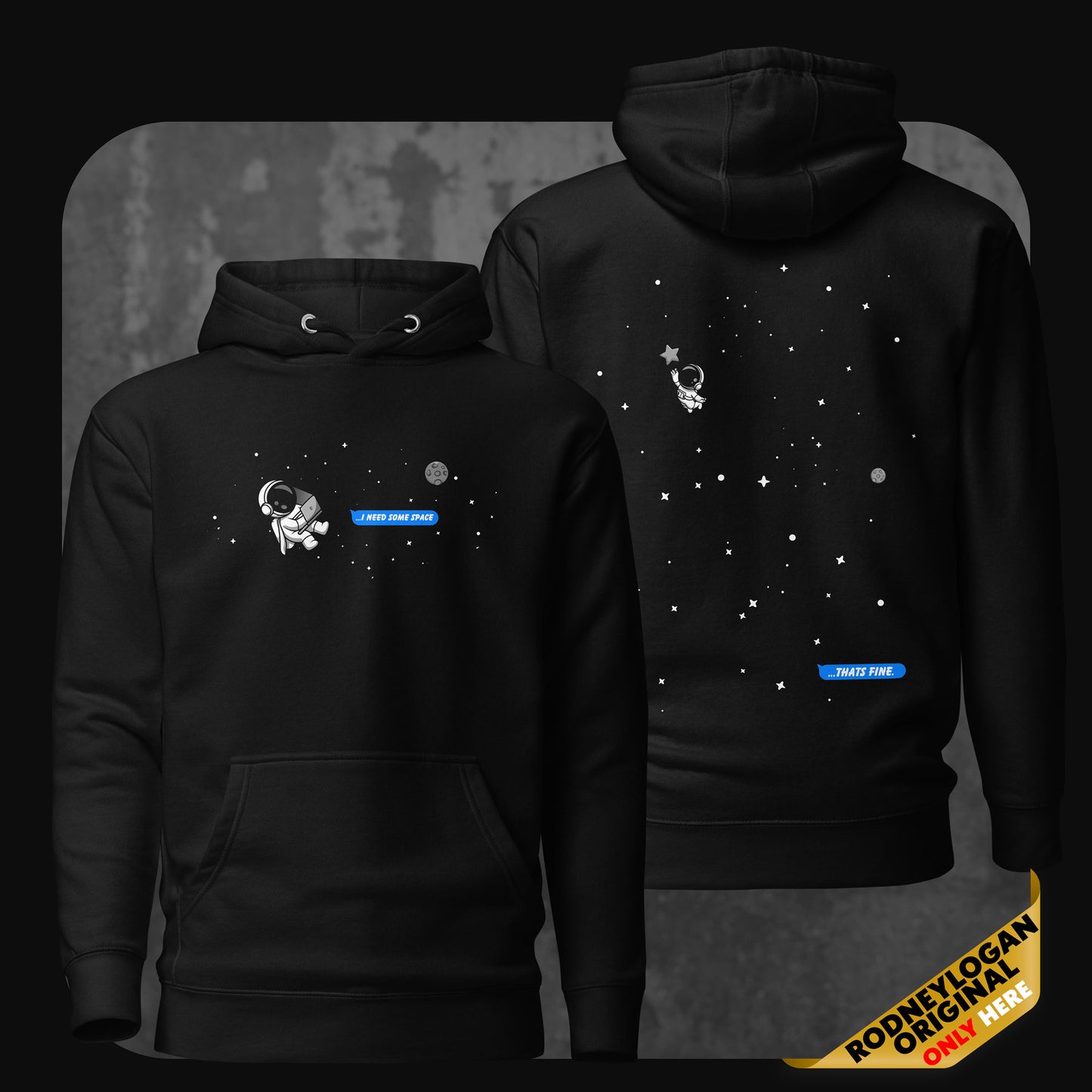 Image of a black hoodie with a small astronaut floating in space and a blue text bubble on the front reading “I need some space”, and on the back the same astronaut drifting further away with a reply bubble saying “That’s fine”.