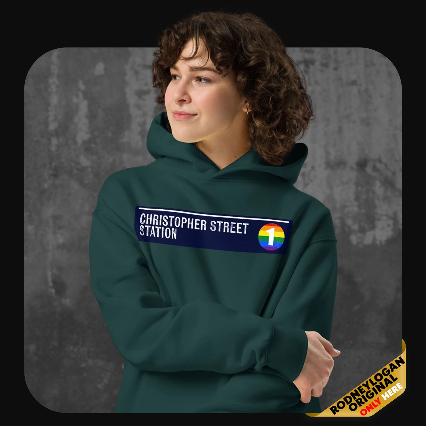 Model wearing a green hoodie with a “Christopher Street Station” patch and a rainbow-colored number 1 subway icon across the chest.