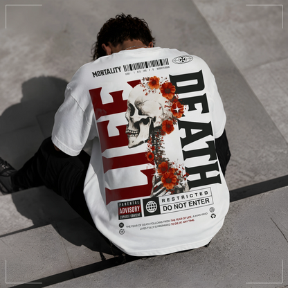 Rodney Logan MORTALITY weißes Oversized Streetwear-T-Shirt mit großem Totenkopf- und Blumen-Backprint sowie "LIFE" und "DEATH"-Schriftzug, getragen von einem sitzenden Model.