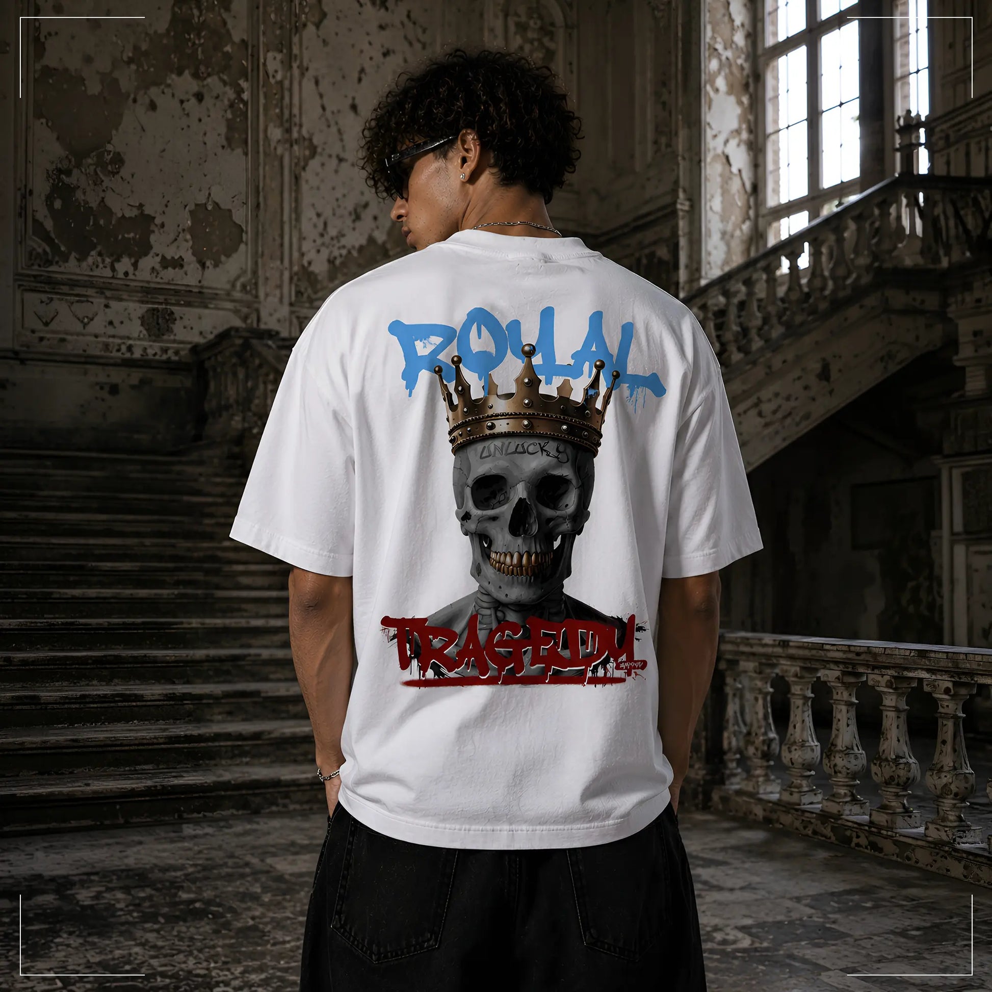 Rückansicht des Rodney Logan ROYAL TRAGEDY weißen Oversized T-Shirts mit großem gekröntem Totenkopf und Graffiti-Schriftzug in Blau und Rot.