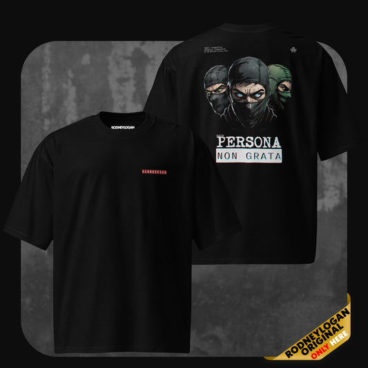 Black oversized t-shirt with “CLASSIFIED” text on the front chest in red, and a large back graphic of three masked figures above the phrase “PERSONA NON GRATA” in bold white letters.