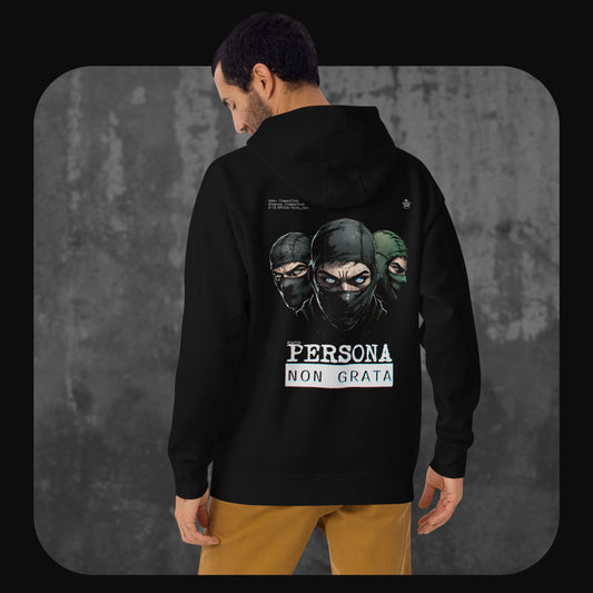 A man with short dark hair and a beard models a black hoodie, facing away from the camera. The back of the hoodie features an illustration of three masked figures and bold white text that reads “Persona Non Grata.”