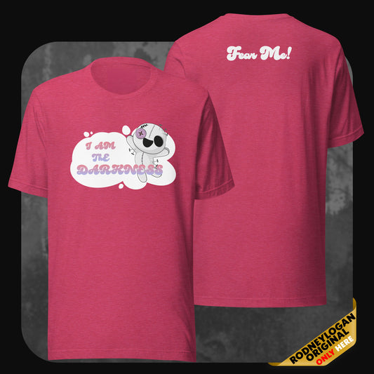 Front and back view of a pink t-shirt featuring a cute stitched doll with the phrase “I AM THE DARKNESS” on the front and “Fear Me!” on the back in playful font.